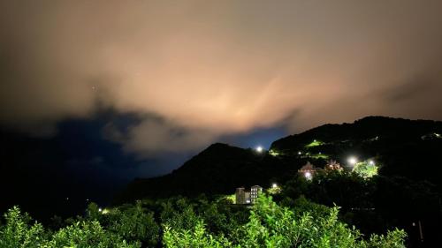 a stormy sky over a mountain at night at Jiufen Gourd Stone TreeHouse 137 in Ruifang