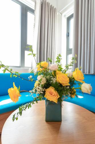 a vase filled with yellow flowers on a table at Rivera Tuy Hòa Hotel in Tuy Hoa
