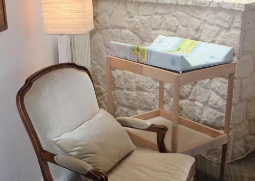 a baby crib sitting next to a table with a chair at Hotel Kazimierzówka in Kazimierz Dolny