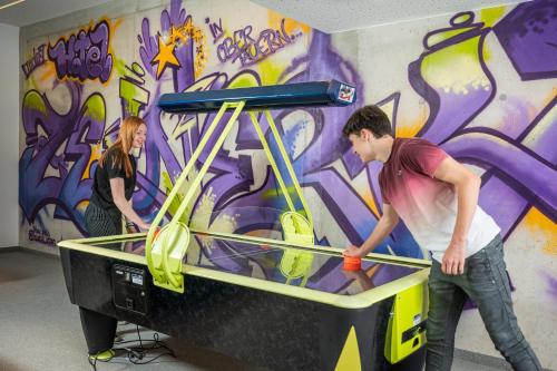 two people standing in front of a table with graffiti at Hotel Zehnerkar & Hotel Obertauern in Obertauern