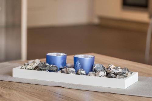 um tabuleiro de pedras numa mesa com duas chávenas azuis em Ferienwohnung Meeresrauschen em Ostseebad Sellin