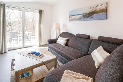 uma sala de estar com um sofá e uma mesa em Ferienwohnung Meeresrauschen em Ostseebad Sellin