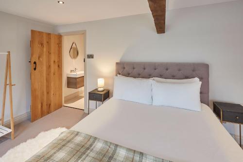 a bedroom with a large white bed and a bathroom at Host & Stay - The Cobbles in Osmotherley