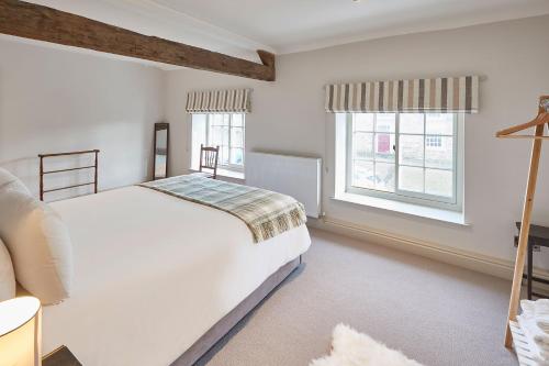 a bedroom with a white bed and two windows at Host & Stay - The Cobbles in Osmotherley