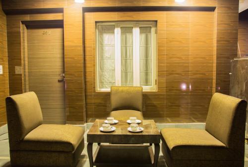 a living room with two chairs and a coffee table at Hotel Pawan Plaza at Karol Bagh in New Delhi