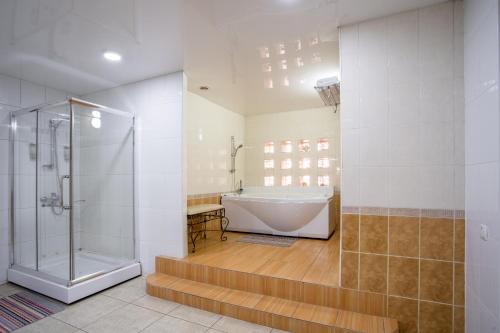 a bathroom with a tub and a walk in shower at Asian Mountains in Bishkek