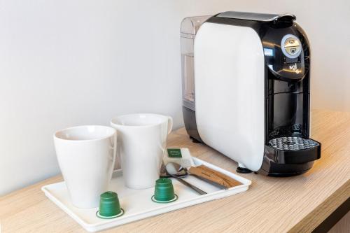 a coffee maker and two cups on a table at B&B HOTEL Almería Vicar in Aguadulce