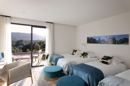 une chambre d'hôtel avec deux lits et un balcon dans l'établissement Villa EVA, vue mer et montagne, plage à pieds, à Sainte-Lucie de Porto-Vecchio
