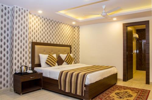 een slaapkamer met een bed en een plafondventilator bij Hotel Pawan Plaza Near Sir Ganga Ram Hospital in New Delhi