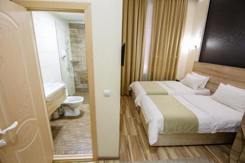 1 dormitorio con 2 camas y baño con aseo en Level en Osh