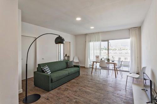 een woonkamer met een groene bank en een tafel bij Deluxe Apartments by Wonderful Italy in Genua