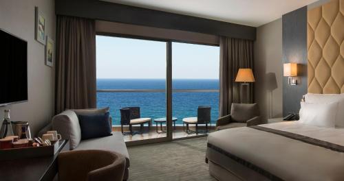 a hotel room with a bed and a view of the ocean at Elexus Hotel Resort & Spa & Casino in Kérynia