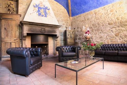a living room with leather furniture and a fireplace at Castello Di Monterone in Perugia