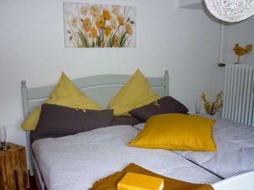 um quarto com uma cama com almofadas amarelas e roxas em LandArt em Olpe