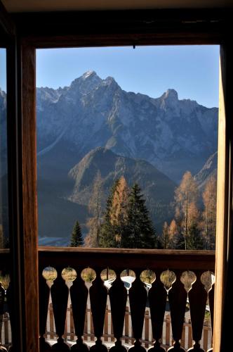 a window with a view of a mountain range at Locanda La Baita in Santo Stefano di Cadore