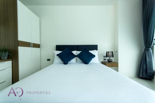 カマラビーチにあるLuxury Lagoon 1bedroom Apartmentの青い枕が付いた大きなベッドのある寝室