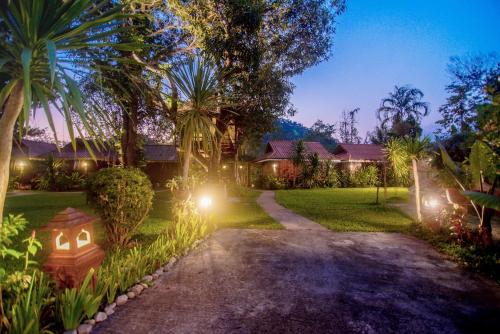 a driveway leading to a house at night with lights at Banviewnam Camping & Resort in Bān Tha Pu Deang
