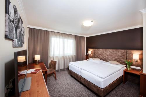 a hotel room with a bed and a desk at Hotel Weinberg GmbH 