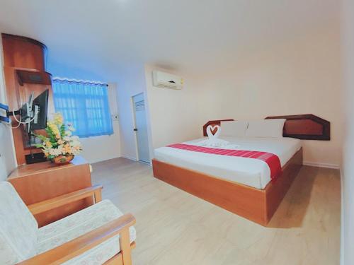 a bedroom with a bed and a chair in it at Imperial Sakon Hotel in Sakon Nakhon