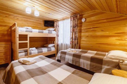 a bedroom with two beds in a wooden cabin at Sheregesh's Wood Chalets & Apartments in Sheregesh