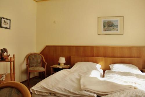 ein Schlafzimmer mit einem Bett mit einem Kopfteil aus Holz in der Unterkunft Landgasthof Köhlbarg in Hanerau-Hademarschen