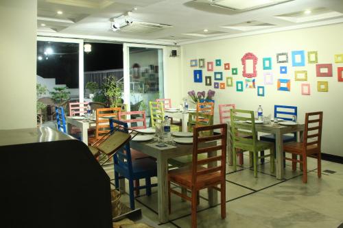 ein Esszimmer mit Tischen und Stühlen und eine Wand mit Bildern in der Unterkunft Hotel Sita International in Neu-Delhi