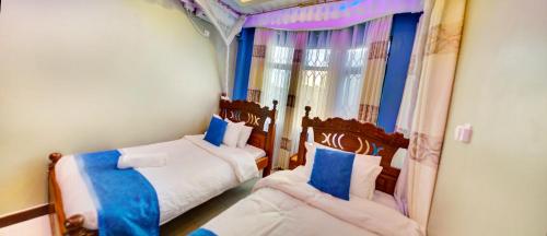 two beds in a room with blue and white at Sunset Paradise Holidays Homes in Shanzu
