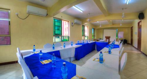 a large room with blue tables and chairs in it at Sunset Paradise Holidays Homes in Shanzu