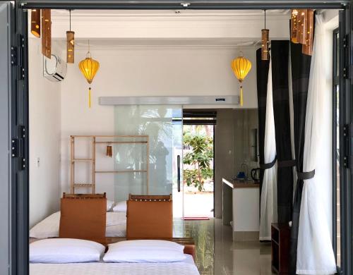 a bedroom with two beds and two lamps at Timothe Beach Apartments in Song Cau