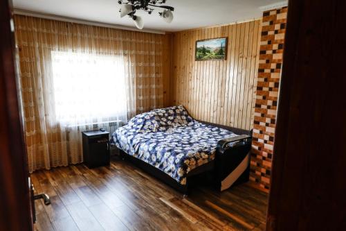 - une chambre avec un lit et une fenêtre dans l'établissement Домашня Оселя, à Yaremtche