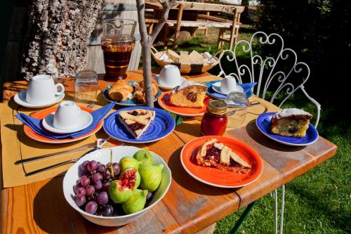 a wooden table with plates of food and fruit on it at Casa Zafferano in Albenga