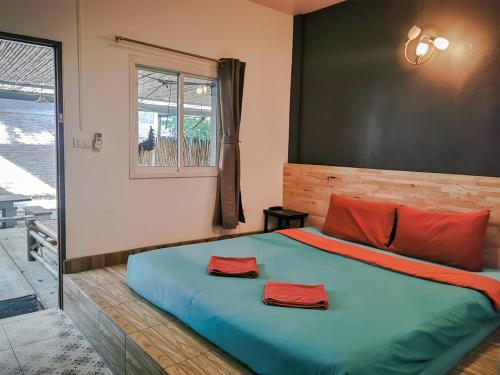 Un dormitorio con una cama grande con almohadas rojas. en Glur Hostel en Ao Nang