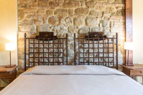 a bed in a room with a stone wall at Castello Di Monterone in Perugia