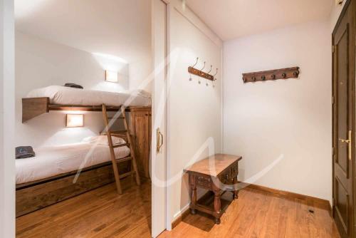 a bedroom with two bunk beds and a table at Amitges by SeaMount Rentals in Baqueira-Beret
