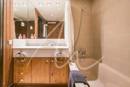 Un baño con bañera, lavabo y ducha. en Sarrahèra by SeaMount Rentals, en Baqueira Beret