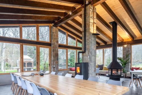 comedor grande con mesa de madera y chimenea en Can Torrotes, en La Vall de Bianya