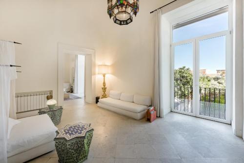 a living room with a bed and a large window at Casa Bormioli - Maison de Charme in Procida