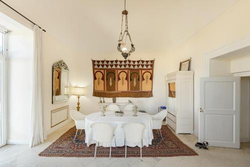 comedor con mesa blanca y sillas blancas en Casa Bormioli - Maison de Charme, en Procida