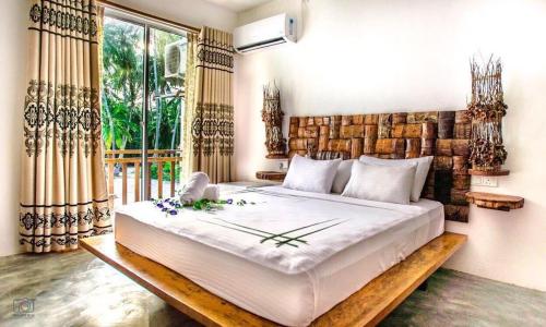 a bedroom with a large bed and a large window at Island Break in Fulidhoo
