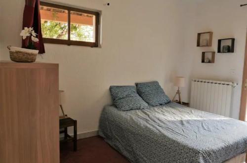 a bedroom with a bed and a window at Gites de la Lurette - agréable T2 indépendant dans cadre calme et verdoyant in Cazilhac