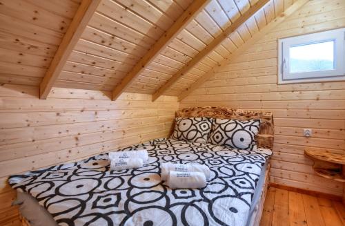 Dormitorio de una cabaña de madera con cama en RUSKA BANIA, en Polańczyk