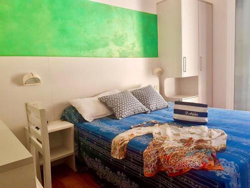 um quarto com uma cama e uma parede verde em Hotel Arena em Rimini