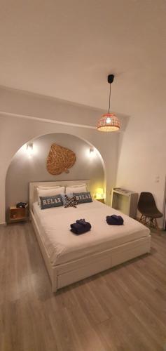 ein Schlafzimmer mit einem großen weißen Bett und einer gewölbten Decke in der Unterkunft HEAVENLY VIEWS-2-APARTMENT with POOL VIEW CLOSE TO THE BEACH! in Oropos