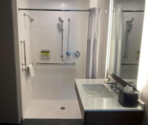 a white bathroom with a shower and a sink at Staybridge Suites Phoenix Glendale Sports Dist by IHG in Glendale
