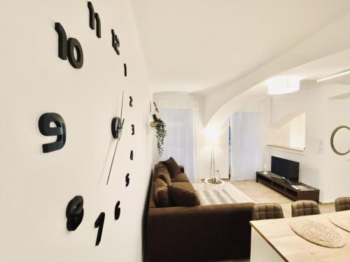 a living room with a couch and clocks on the wall at The Luxury Loft Vienna in Vienna
