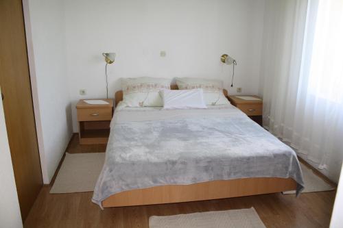 a bedroom with a large bed with two night stands at Apartmani Mijatović in Lopar