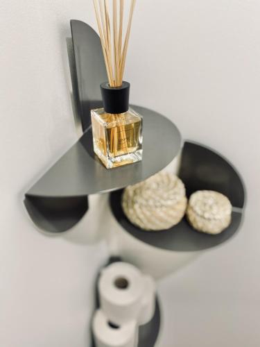 a shelf with a bottle of perfume and rolls of toilet paper at The Luxury Loft Vienna in Vienna