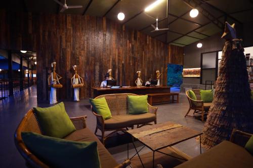 a restaurant with green pillows and chairs and a table at Wayanad Wild - A CGH Earth Experience in Vythiri