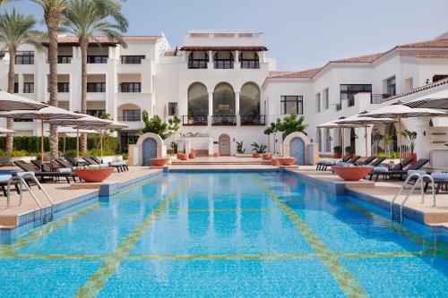 a swimming pool in front of a hotel at Address Marassi Golf Resort in El Alamein