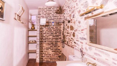 baño con pared de ladrillo y lavamanos en Lagar de Viña Vieja, en Cazalla de la Sierra